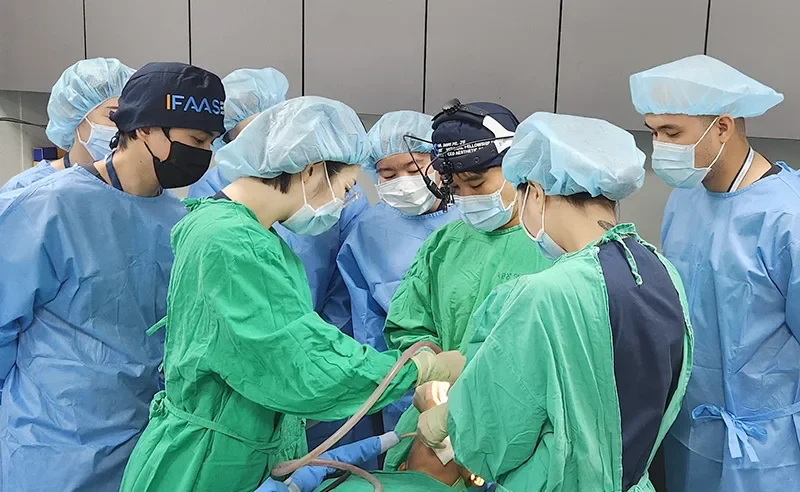 Performing live facial contouring surgery demonstrations for medical professionals